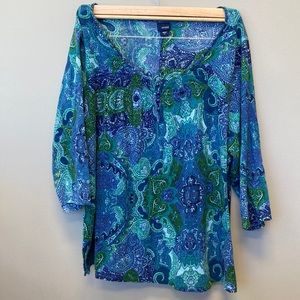 Woman’s paisley designed blue and green blouse.